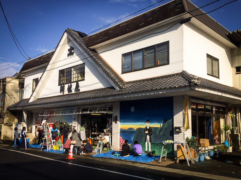 あわや竹田店舗のシャッターに絵を描く大分県立芸術文化短期大学の学生たち